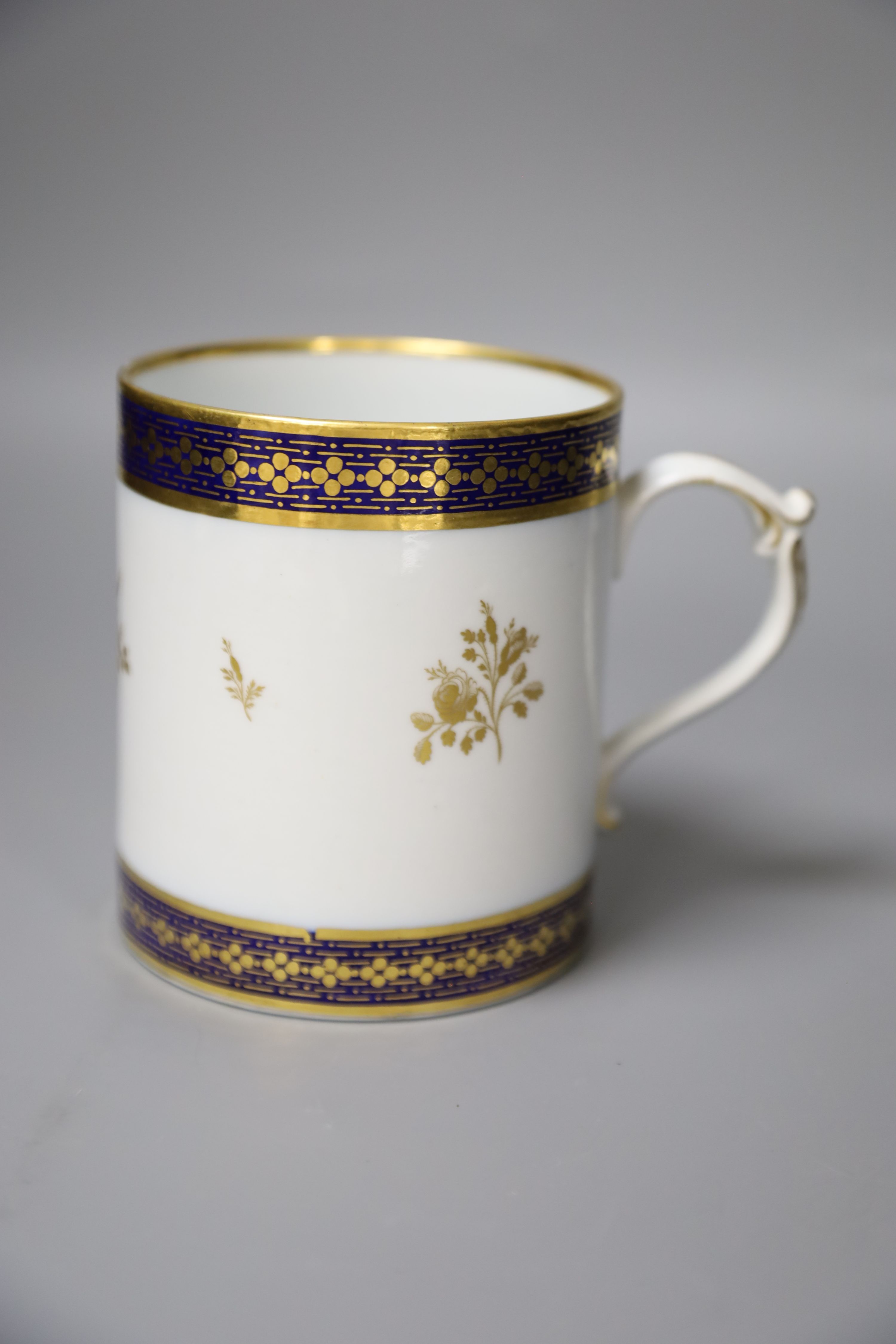 A 19th century Barr Worcester fine mug with a distinctive handle painted in under glaze blue and gilded with floral sprays, height 11cm